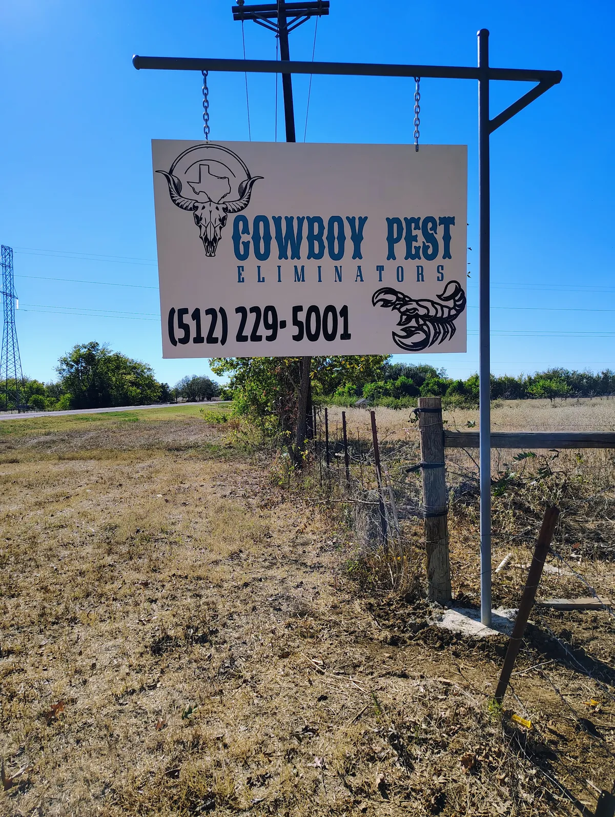 Cowboy Pest Eliminators roadside sign with phone number